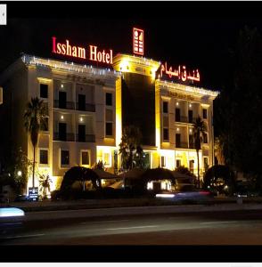 a hotel with a sign on top of it at night at Issham Hotel in Jeddah