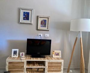 a living room with a television on a wooden table at Relax e tranquillità a Cala Pisana in Lampedusa