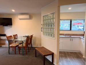 a kitchen and dining room with a table and chairs at Tudor Lodge Motel in Nelson +46 photos