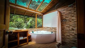 a bath tub in a bathroom with a window at LA RUSTICA MiNDO in Mindo