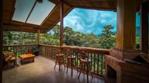 a screened in porch with chairs and a table on it at LA RUSTICA MiNDO in Mindo +5 photos