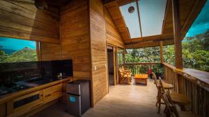 a cabin with a kitchen and a balcony at LA RUSTICA MiNDO in Mindo