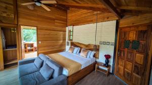a bedroom with a bed and a blue couch at LA RUSTICA MiNDO in Mindo