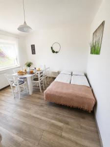 a bedroom with a bed and a table with chairs at apartma Vila TARA in Prebold