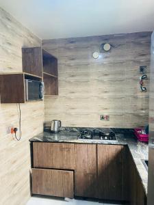 a kitchen with a stove and a microwave at Double Homes in Agbelekale