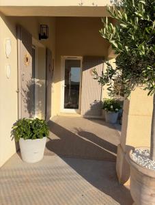 a front porch of a house with two potted plants at Suite dans un petit paradis in La Londe-les-Maures