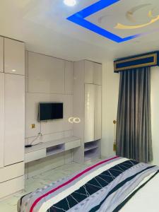 a bedroom with a bed and a tv on the ceiling at Double Homes in Agbelekale