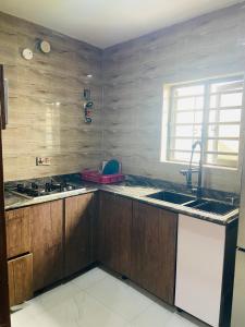 a kitchen with wooden cabinets and a sink at Double Homes in Agbelekale