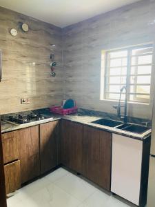 a kitchen with wooden cabinets and a sink and a window at Double Homes in Agbelekale +98 photos