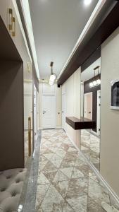 a hallway with a large hallway with a door and a tile floor at Yassi Apartment in Türkistan +1 photo