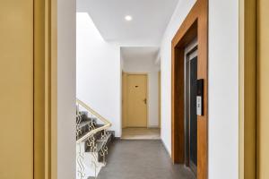 a hallway with stairs and a yellow door at FabHotel Amar Residency, Sector 7, Dwarka in New Delhi +28 photos
