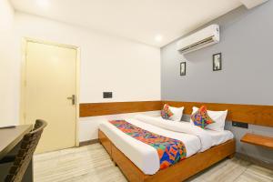 a bedroom with a bed and a table and a door at FabHotel Amar Residency, Sector 7, Dwarka in New Delhi
