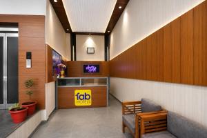 a waiting room with a tv and a chair at FabHotel Amar Residency, Sector 7, Dwarka in New Delhi