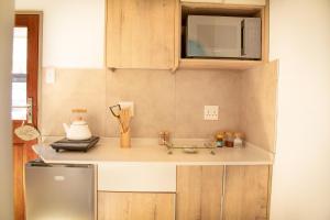 a kitchen with a sink and a microwave at Jac-Marie guests accommodation in Tzaneen +20 photos