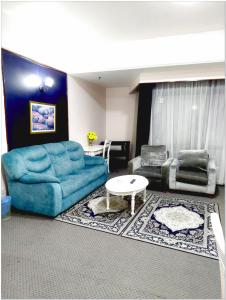 a living room with a blue couch and a table at Concord service suite time square in Kuala Lumpur