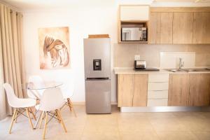 a kitchen with a refrigerator and a table and chairs at Jac-Marie guests accommodation in Tzaneen