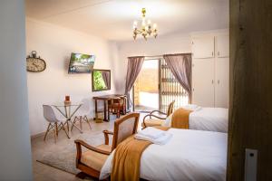 a room with two beds and a table and chairs at Jac-Marie guests accommodation in Tzaneen