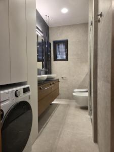 a bathroom with a sink and a washing machine at Apartments Romana in Postira +70 photos