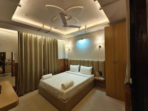 a bedroom with a bed with a ceiling fan at Hotel hk haridwar By hk guest house in Haridwār