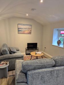 a living room with two couches and a table at Waterfall Cottage in Killybegs
