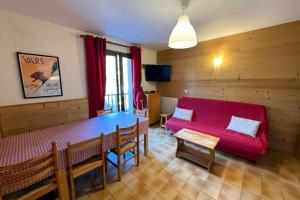 a living room with a red couch and a table at Chalet 8 pers Vars SteMarie Calme in Vars +9 photos