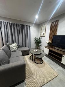 a living room with a couch and a television at Phumlani Village Lodge in White River