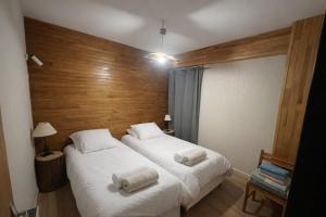 two beds in a small room with wooden walls at Chalet 8 pers Vars SteMarie Calme in Vars
