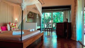 a bedroom with a bed with a canopy at Hotel Arc En Ciel in Dzamandzar
