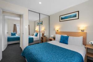 a hotel room with two beds and a mirror at Bay View Villas in Hobart +57 photos