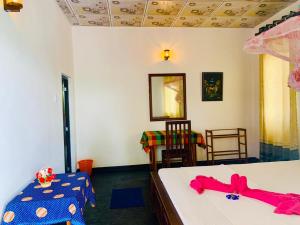 a bedroom with two beds and a table and chairs at Die Elefanten Udawalawe in Udawalawe