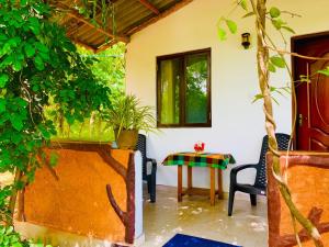 a patio with a table and chairs and a tree at Die Elefanten Udawalawe in Udawalawe