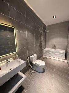 a bathroom with a toilet and a sink and a tub at Hotel Trung Đông 2 in Ấp Bình Thương