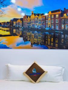 a bed with a pillow and a picture of a city at Hotel Trung Đông 2 in Ấp Bình Thương
