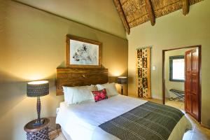 a bedroom with a bed and a lamp in it at Sable Ranch Bush Lodge in Brits +89 photos