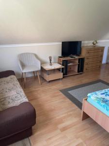 a living room with a couch and a tv at Kamilla Apartman in Fonyód
