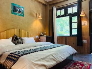 a bedroom with a large bed and a window at Pond & Stone Homestay in Banjār +35 photos