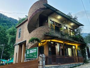 a building with a balcony on the side of it at Pond & Stone Homestay in Banjār