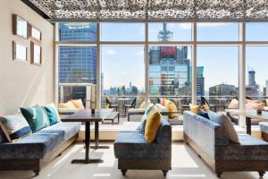 a large room with couches and a large window at Hyatt Centric Times Square New York in New York