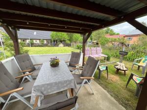 a patio with a table and chairs and a grill at Ferienhaus Kluttig in Hörnitz