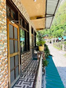 a building with a blue walkway next to a building at Pond & Stone Homestay in Banjār