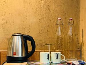 a tea kettle and two glass bottles on a table at Pond & Stone Homestay in Banjār