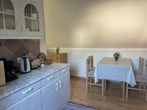 a kitchen with a counter and a table and a table and chairs at Kamilla Apartman in Fonyód +2 photos