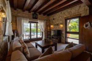 a living room with a couch and a table at Eco Stone Villa with Private Pool and Jacuzzi in Kalandra