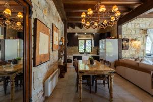 a kitchen and dining room with a table and refrigerator at Eco Stone Villa with Private Pool and Jacuzzi in Kalandra