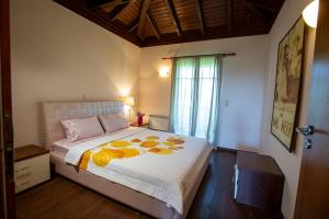 a bedroom with a bed with yellow flowers on it at Eco Stone Villa with Private Pool and Jacuzzi in Kalandra +63 photos