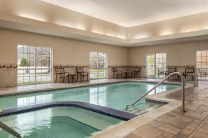 a pool in a hotel with tables and chairs at Hyatt House Fishkill-Poughkeepsie in Fishkill