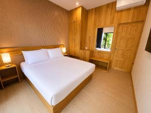 a bedroom with a white bed and a window at Isola Alifu in Feridhoo