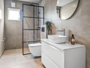 a bathroom with a toilet and a sink and a shower at Deluxe Family Apartment in Egilsstaðir in Egilsstaðir +25 photos