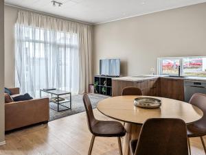 a living room with a table and a kitchen at Deluxe Family Apartment in Egilsstaðir in Egilsstaðir