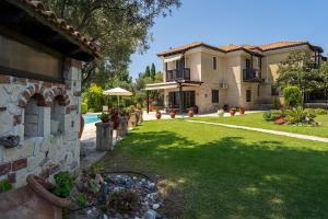 a backyard of a house with a lawn and a house at Eco Stone Villa with Private Pool and Jacuzzi in Kalandra